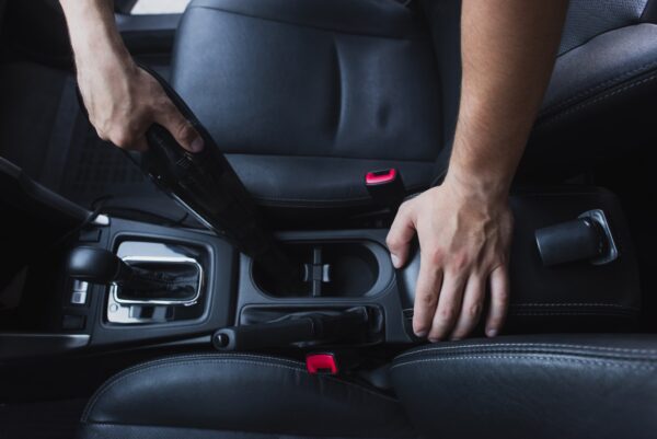 cropped view of car cleaner vacuuming car interior